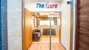 A modern interior with a reception desk, seating area, and a sign reading "The Azure". - Fabhotel Azure (Mumbai)