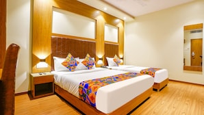 A hotel room with two beds, wooden headboards, and bedside lamps. - Fabhotel Azure (Mumbai)