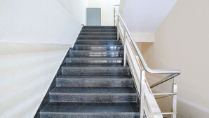 A staircase with metal handrails and a light-colored wall. - Fabhotel Azure (Mumbai)