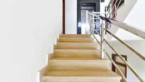 Una escalera con escalones de madera y barandillas de metal.