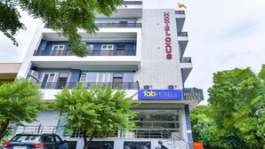 Un hotel de varios pisos con balcones y un letrero que dice "HOTEL OXUS".