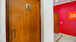 Una puerta de madera con un tirador de latón y una placa decorativa cuadrada.
