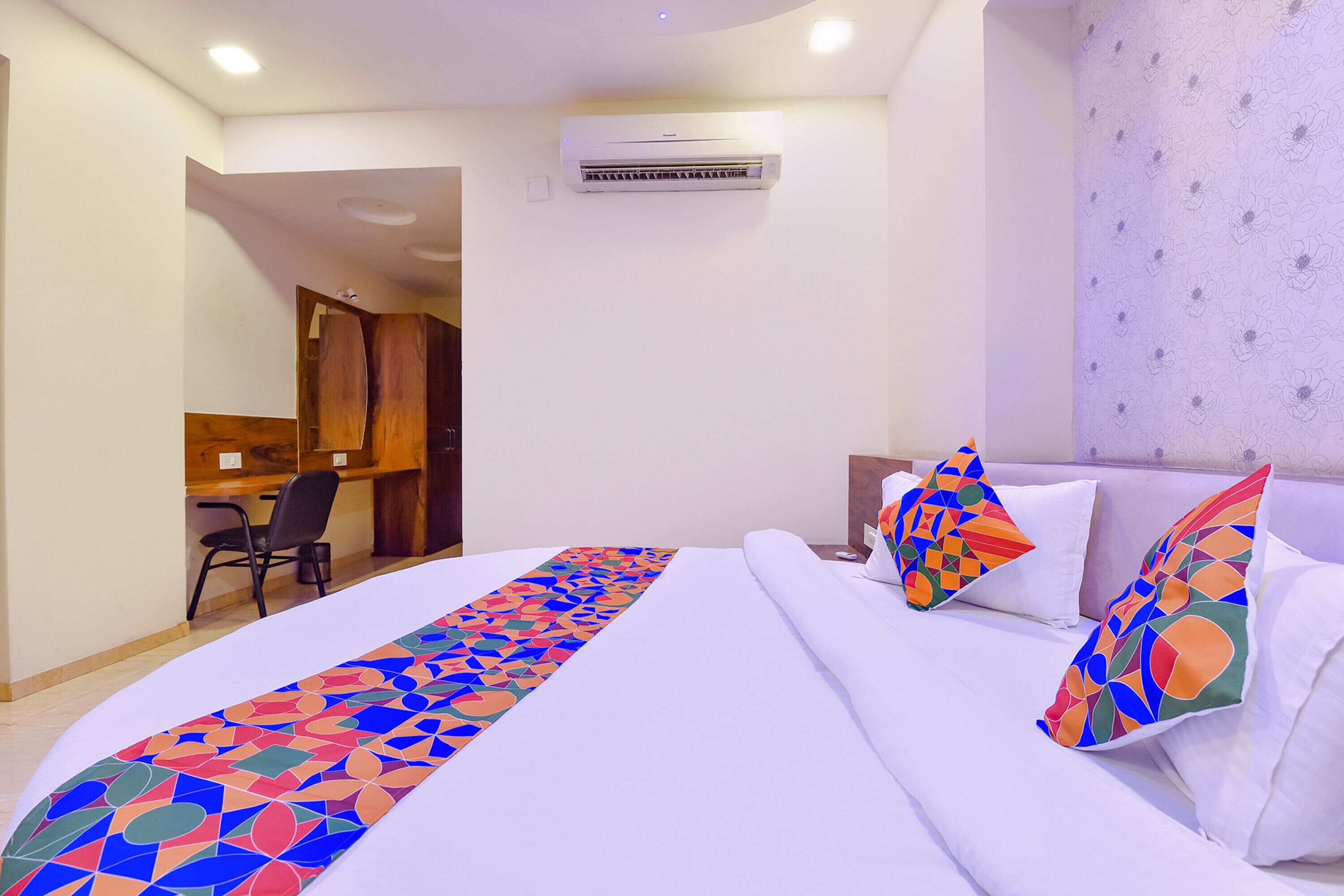 Ein Hotelzimmer mit Bett, Schreibtisch und Klimaanlage.