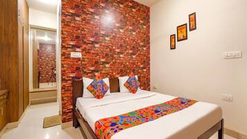 Cozy retreat with a brick-patterned accent wall, colorful bedspread, and framed artwork.