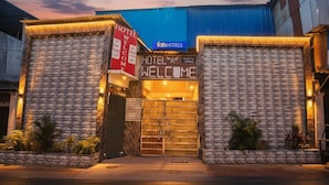 A hotel entrance with a 'Welcome' sign, a 'Hotel Welcome' sign, and a 'FabHotels' sign. - Fabhotel Welcome (Kanpur)