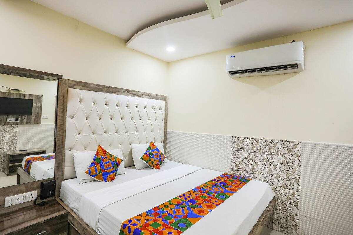 Habitación de hotel con una cama grande, televisión de pantalla plana, teléfono y aire acondicionado.