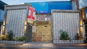 A hotel entrance with a 'Welcome' sign, a 'Fab Hotels' sign, and a blue awning. - Fabhotel Welcome (Kanpur)