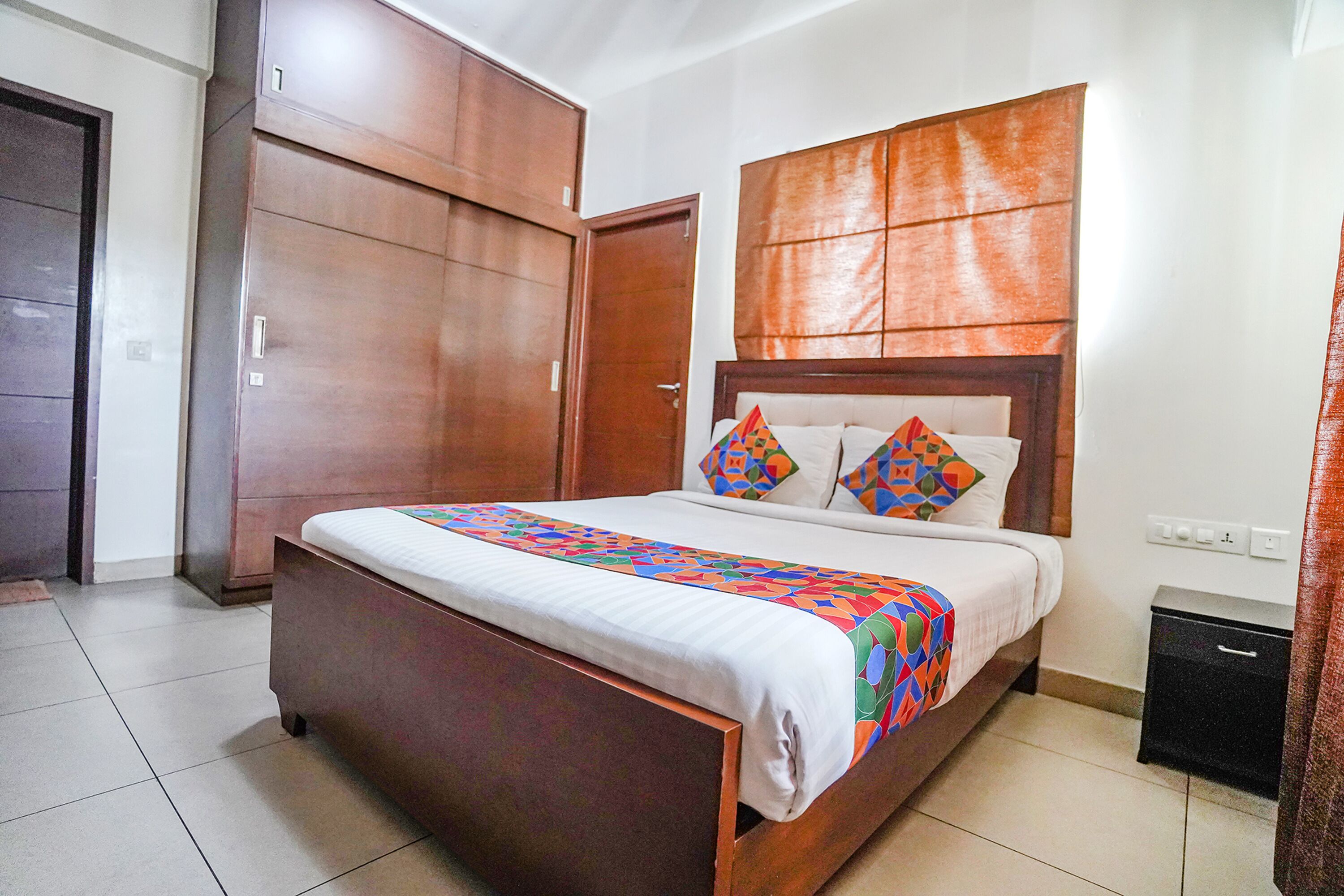 A bedroom with a wooden bed, a nightstand, and a wardrobe.