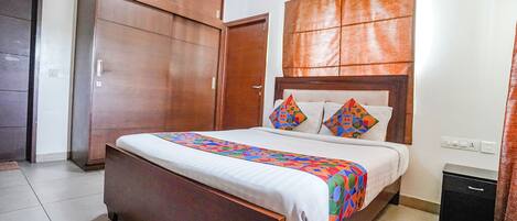 A bedroom with a wooden bed, a nightstand, and a wardrobe.