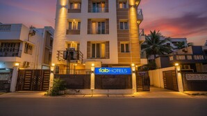 Il s'agit d'un hôtel moderne, reconnaissable à son enseigne où l'on peut lire « fab hotels ». Il comprend plusieurs étages, des balcons et une entrée sécurisée par un portail.