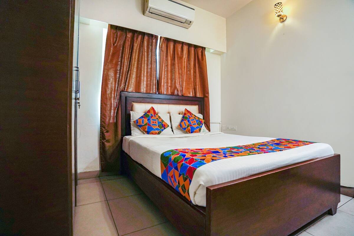 A bedroom with a wooden bed, a white mattress, and a colorful quilt.