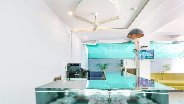 Un soggiorno moderno con un tavolino in vetro, una ventola a soffitto, una televisione e un divano giallo.