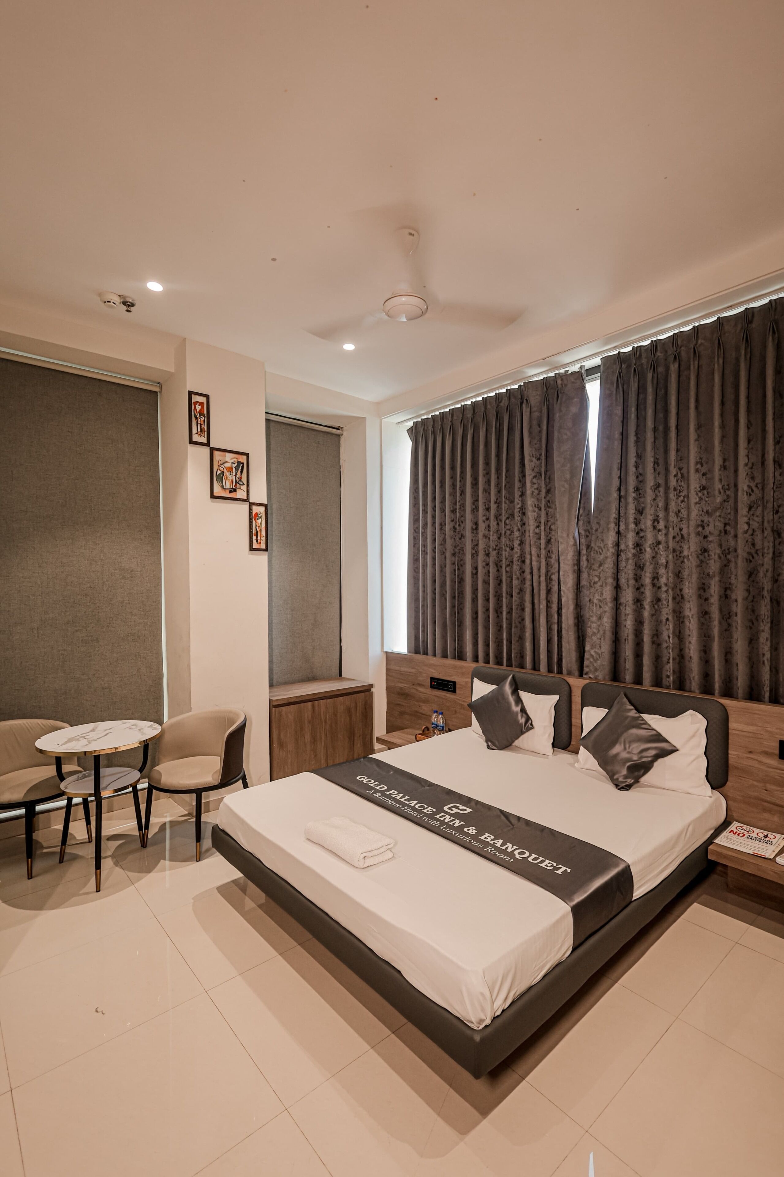 Una habitación de hotel moderna con una cama grande, una mesita y una silla.