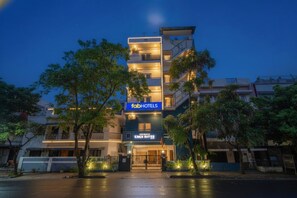 Un edificio de varios pisos con un letrero que dice 'fabHOTELS' y 'Kings Suites'.