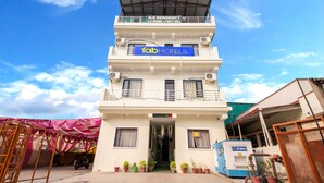 Un edificio de varios pisos con un letrero que indica 'fabHOTELS' y 'A.S. RESIDENCY', señalando un complejo hotelero y de residencias.