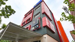 Un edificio de varios pisos con techo plano, grandes ventanales y un cartel que indica que es un hotel.