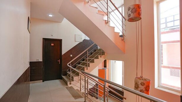 Un interior moderno con una escalera, una puerta y una ventana.