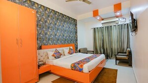 Un dormitorio con cama, armario, escritorio y aire acondicionado.
