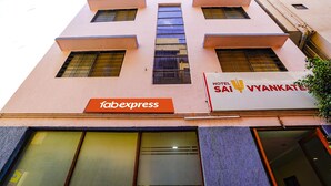 Fachada de hotel con múltiples ventanales y un letrero de 'fabexpress'.