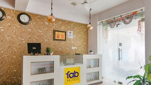 A reception desk with a 'fab hotels' sign, a clock, and a framed picture on the wall. - Fabhotel Vinayaka (Patna)