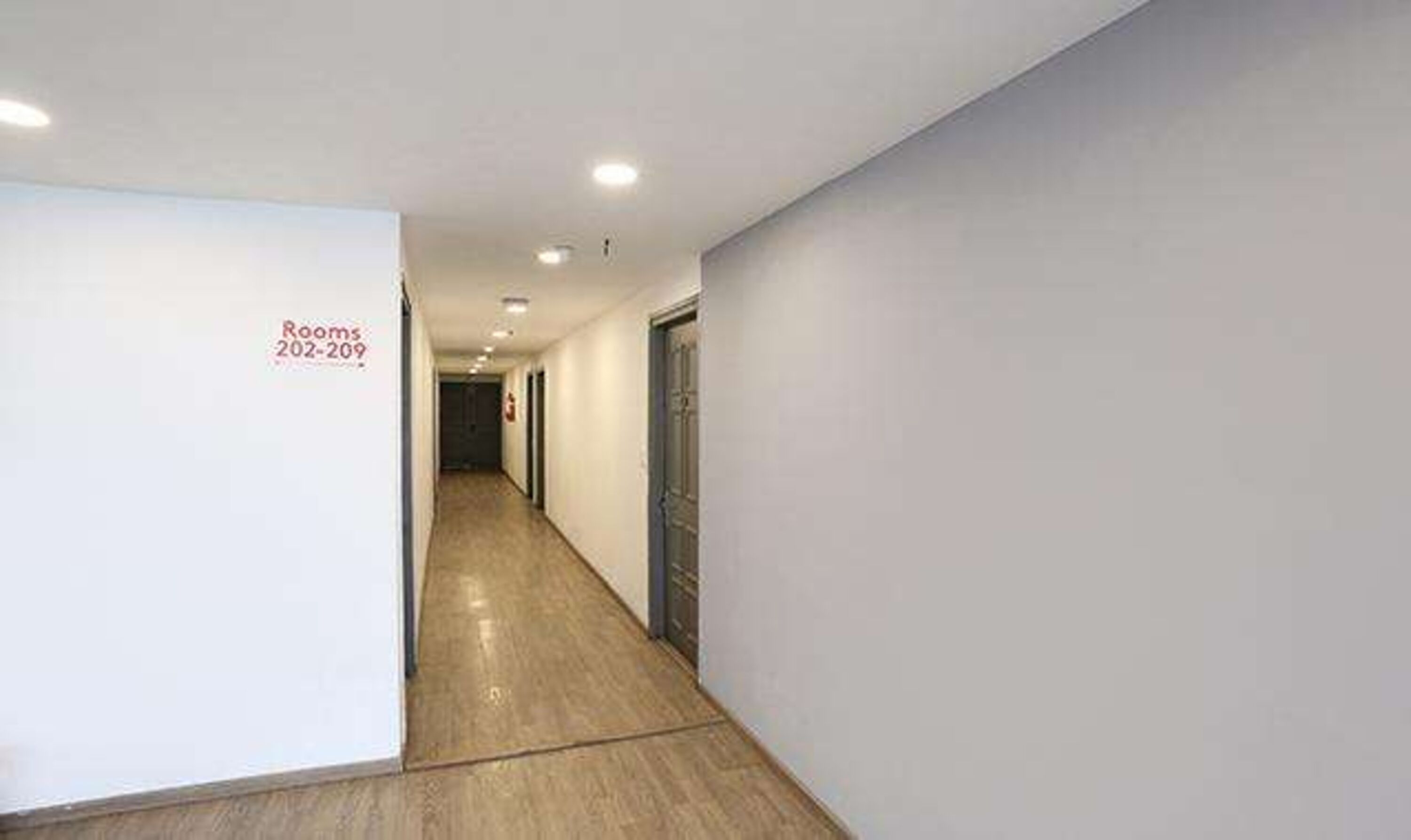 A hallway with a sign indicating rooms 202-209.