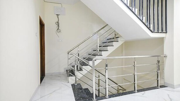 A modern staircase with metal railings and a glass railing, leading to an upper floor. - Fabhotel Dr Greens (Indore)