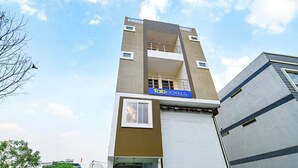 A modern hotel building with a prominent 'fab hotels' sign, a large window on the ground floor, and a flat roof. - Fabhotel Dr Greens (Indore)