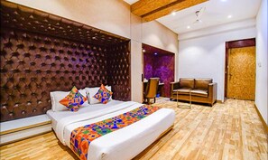 Ein modernes Hotelzimmer mit einem großen Bett, einer Ledersofa und einem Holzboden.