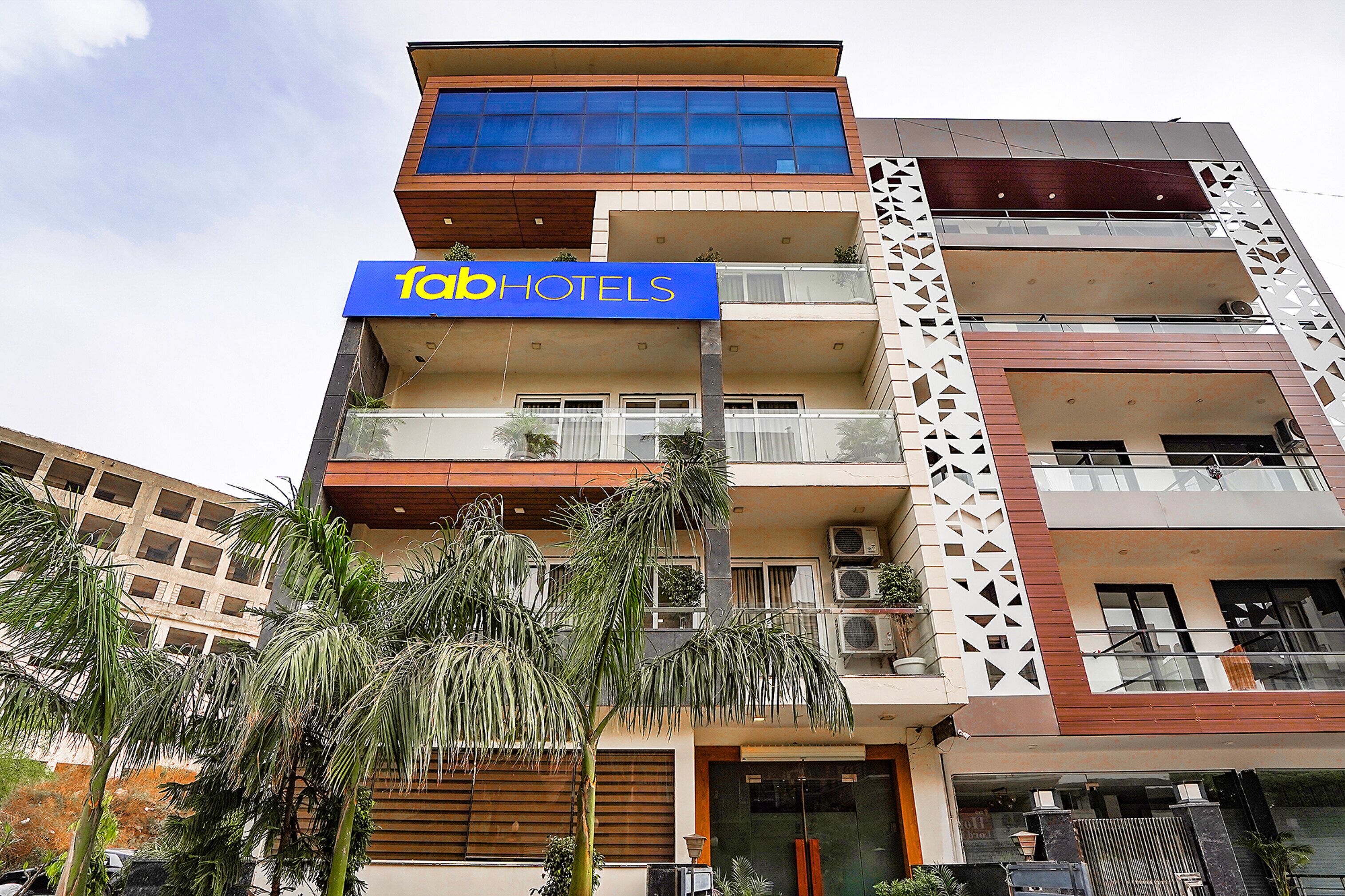 A multi-story building with a 'fab hotels' sign, balconies, and air conditioning units.