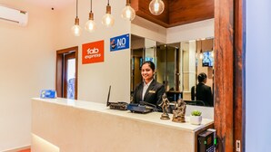 A hotel reception desk with a receptionist, a NO sign, and a Fab Express sign. - FabHotel Ascot International (Mumbai)