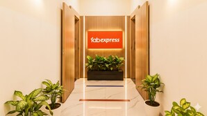 A lobby with a 'Tabexpress' sign, potted plants, and a marble floor. - FabHotel Ascot International (Mumbai)