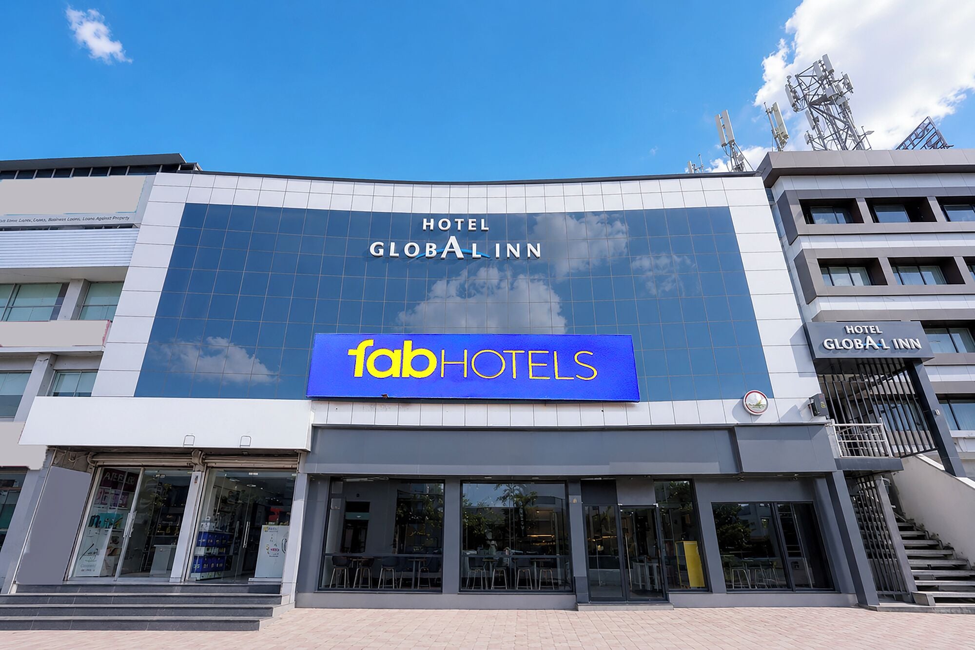 A hotel with a large sign reading 'GLOBAL INN' and a smaller sign for 'faabHOTELS' below it.