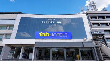 A hotel with a large sign reading 'GLOBAL INN' and a smaller sign for 'faabHOTELS' below it.