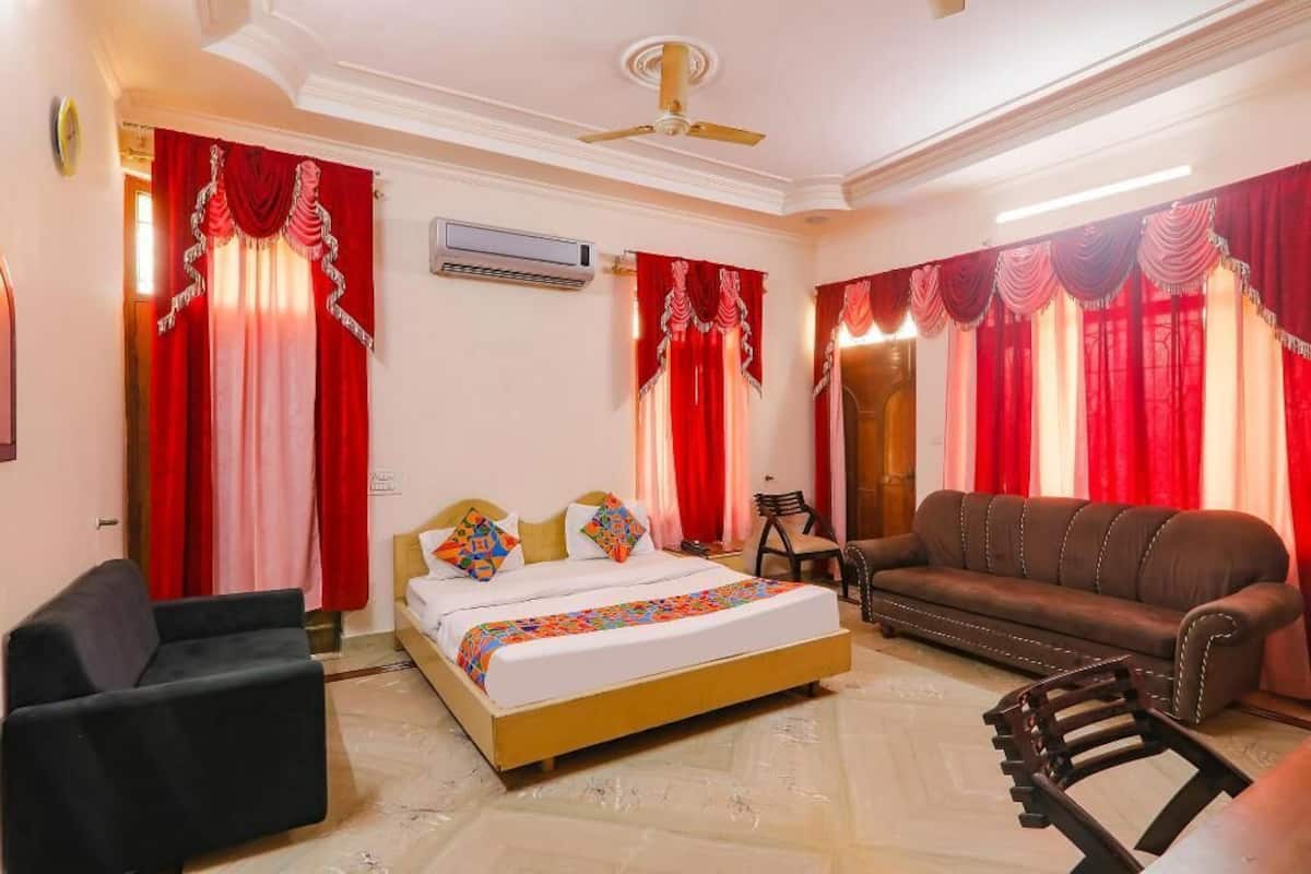 Ein Hotelzimmer mit Bett, Sofa, Sessel und Deckenventilator.
