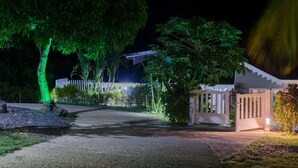 A gated residential area at night with a driveway leading to a house. - Luxury villas with private pools in the countryside (Le Marin)