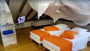 A bedroom with two beds, a TV, and a shelf with folded towels. - Luxury villas with private pools in the countryside (Le Marin)