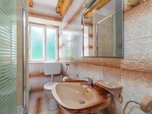 Un baño con lavamanos, inodoro y ventana.