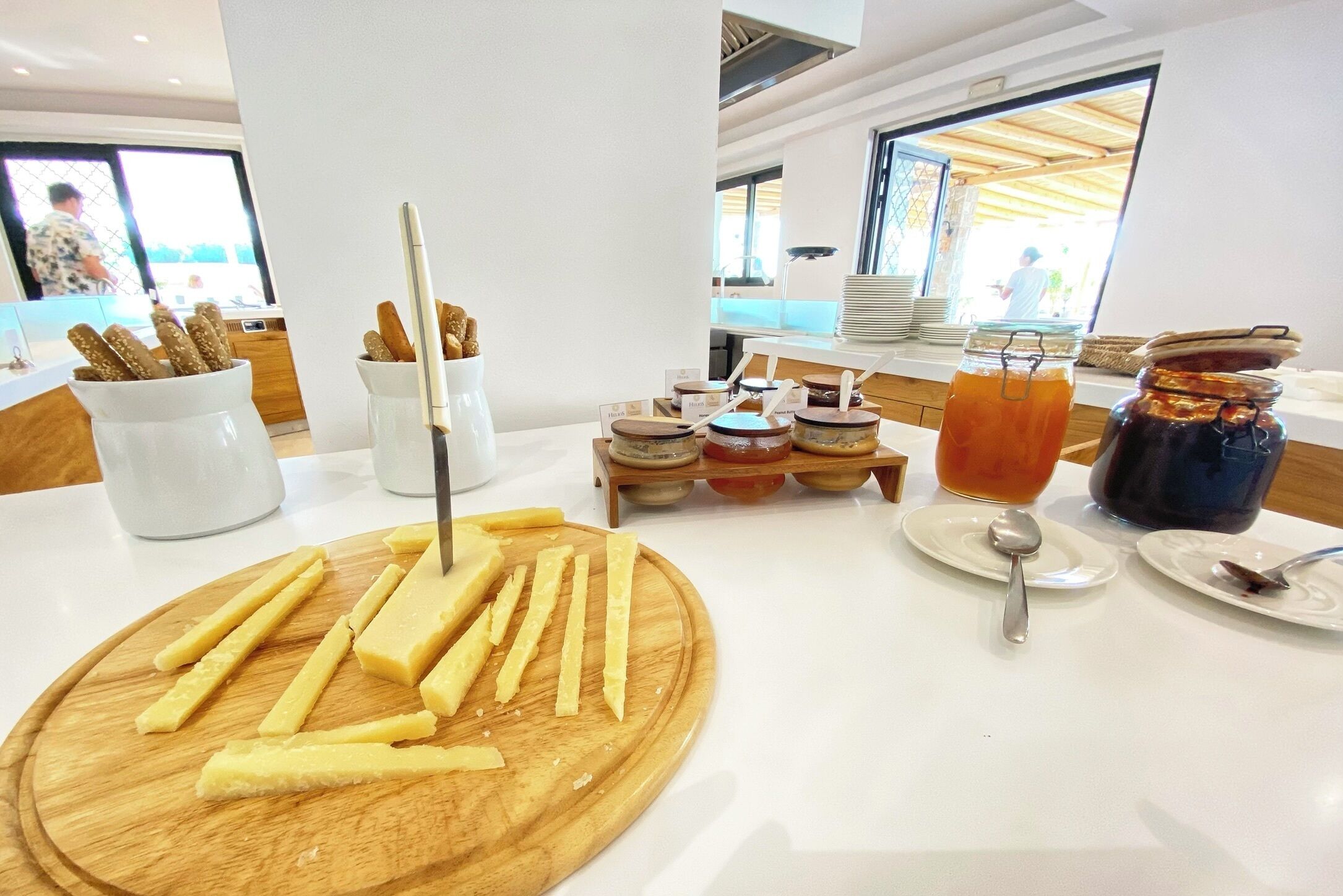 A breakfast buffet with cheese, bread, and condiments.