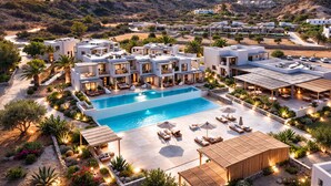 Un moderno resort con piscina central, numerosas habitaciones y jardines ajardinados.