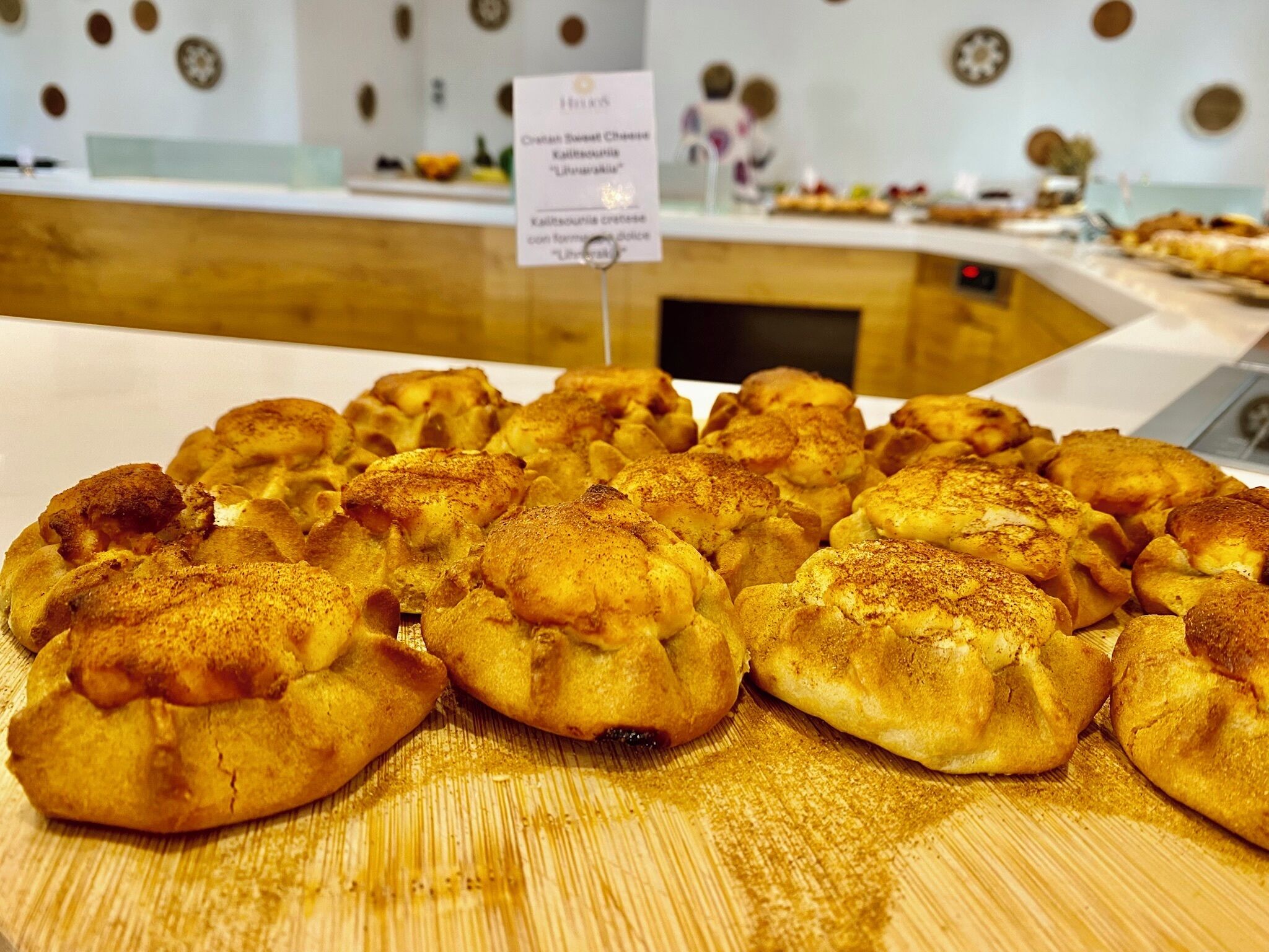 A display of pastries on a wooden table with a sign indicating a dessert menu.