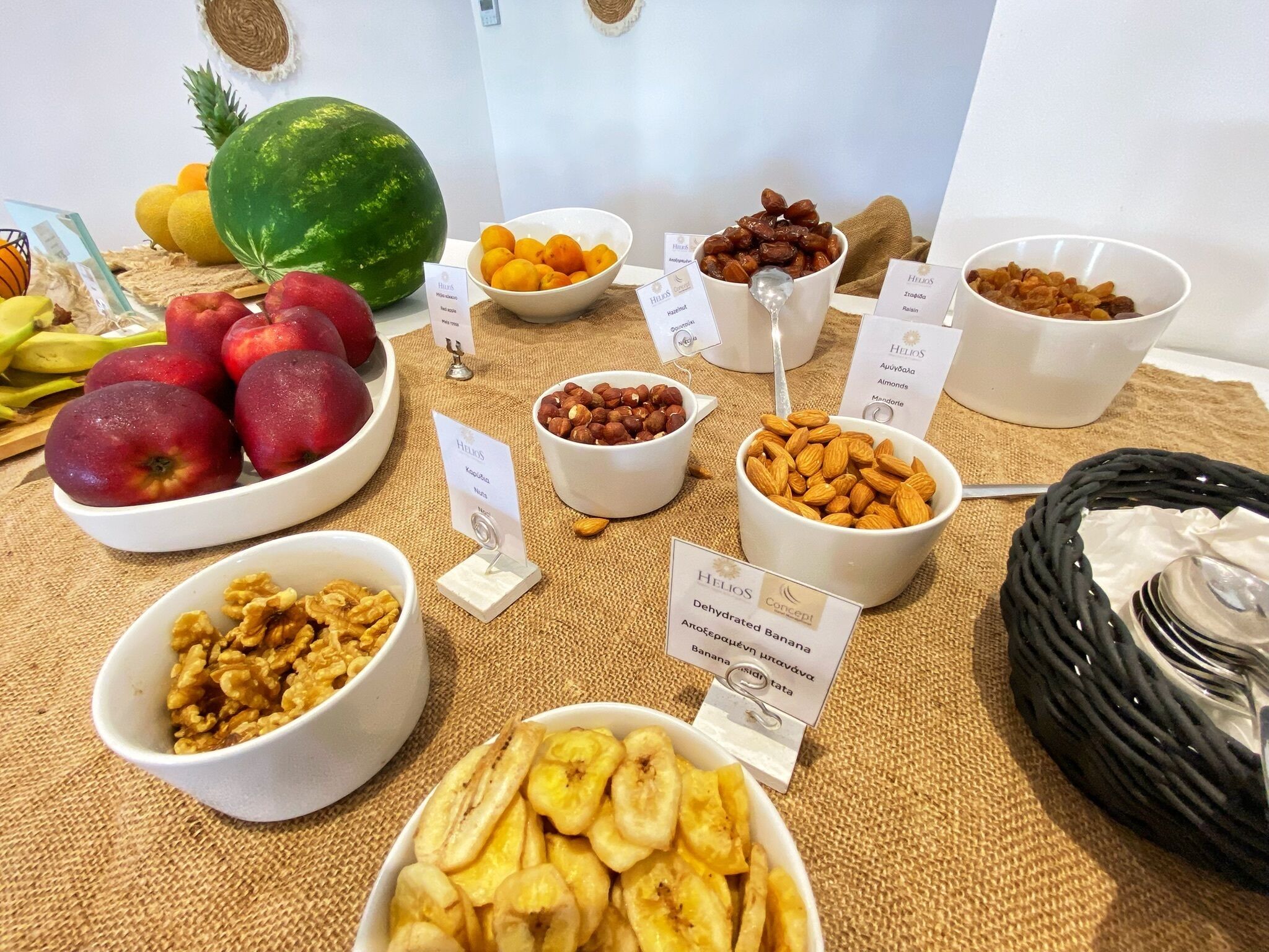 Une variété de fruits et de noix disposés sur une table, chacun étant accompagné d’une étiquette.