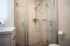 A modern bathroom with a glass-enclosed shower, a toilet, and a sink. - Herzlich Willkommen in Unserem Liebevoll Eingerichtetem Appartement "albatros" (Büsum)
