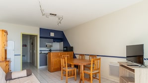 A compact living space with a kitchenette, a dining area, and a TV. - Mimizan Beach: 6-person apartment with balcony and parking (Mimizan)