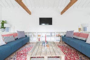 Relax in this stylish living room with a central coffee table, two sofas, and a flat-screen TV.