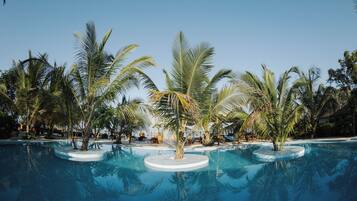 A pool surrounded by palm trees and a clear sky.