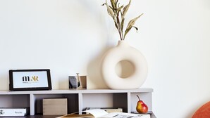Un espacio de trabajo moderno con escritorio, silla y una lámpara colgante.