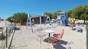 Une aire de jeux avec des balançoires, des toboggans et des structures d’escalade.
