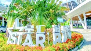 A modern building with large signage reading "STAR PARK" surrounded by lush greenery and palm trees. - Star Bay Residence (Sihanoukville)