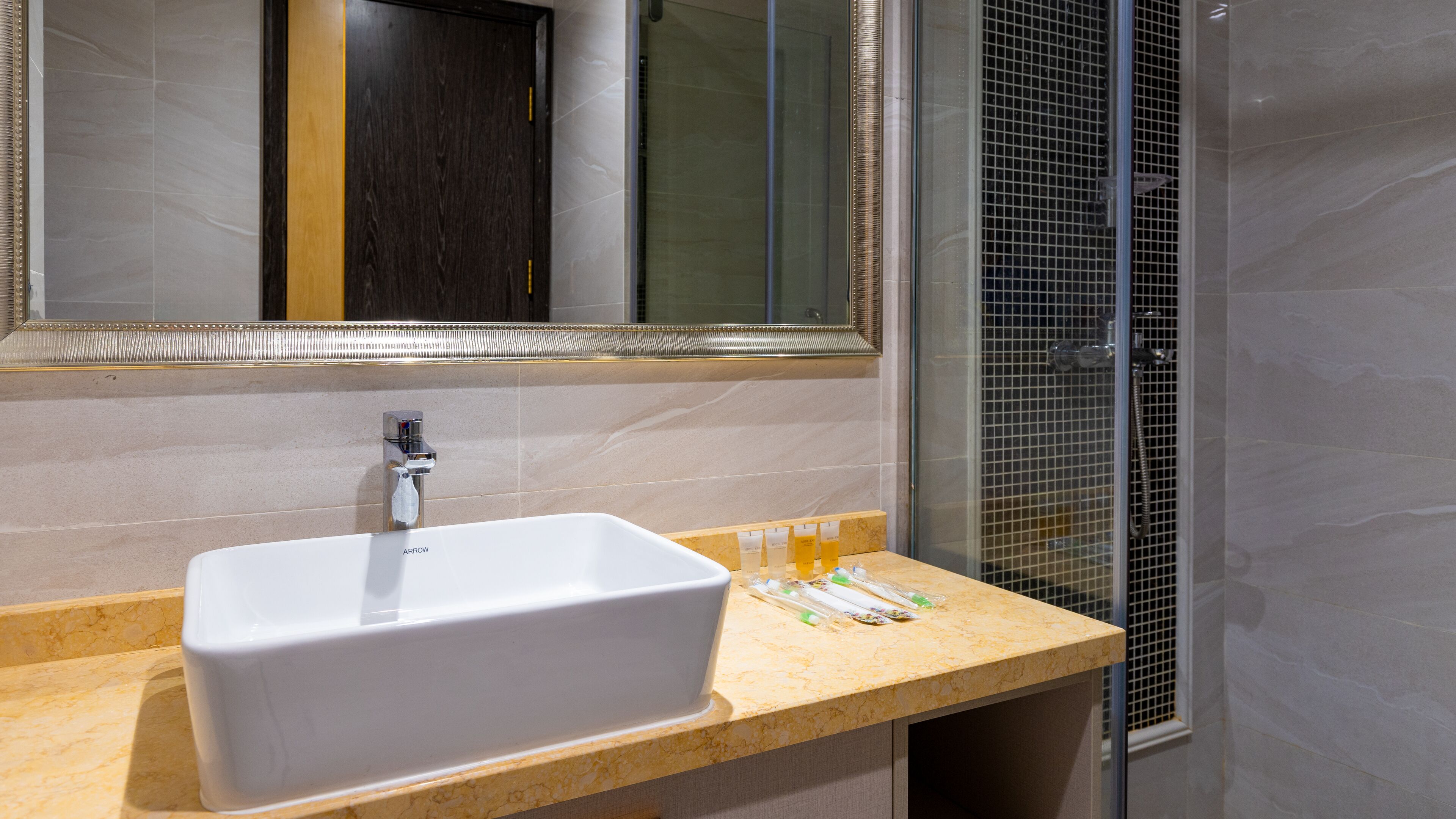 A bathroom with a white sink, a mirror, and a shower enclosure.