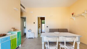 A dining area with a white table and chairs, a colorful cabinet, and a bench in the background. - 3294 Villa Dolce Grazia by Barbarhouse (Manduria)